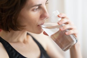 Photo of a woman drinking a glass of water